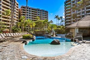 a swimming pool in a resort with palm trees and buildings at Kaanapali Alii 4104 in Kaanapali
