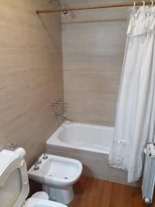 ein Badezimmer mit einer weißen Badewanne, einem WC und einem Waschbecken in der Unterkunft Terrazas del Sur in San Carlos de Bariloche