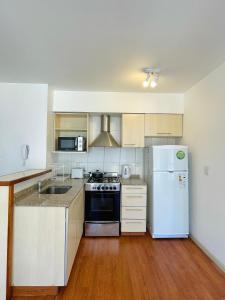 eine Küche mit einem weißen Kühlschrank und einer Spüle in der Unterkunft Terrazas del Sur in San Carlos de Bariloche