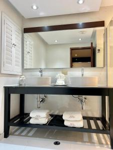 a bathroom with two sinks and a large mirror at Hotel Caesars in Tijuana