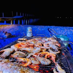 a grill with seafood and a can of beer on it at May Beach Resort in Koh Rong Island