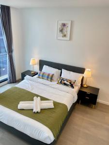 a bedroom with a large bed with towels on it at Skygarden On The Glen in Glen Waverley
