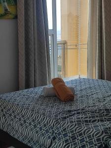 a bed with a pillow on it with a window at Birch Tower by Tristoff in Manila