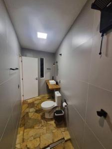 een badkamer met een wit toilet in een kamer bij Casa do Descanso com jacuzzi em Igaratá in Igaratá