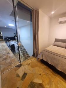 - une chambre avec un lit et un mur en verre dans l'établissement Casa do Descanso com jacuzzi em Igaratá, à Igaratá