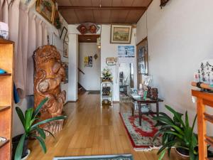 una sala de estar con una gran estatua de madera en el centro en Kawabata Ryokan Takehara by Tabist, en Takekara