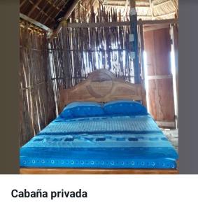 a wooden bed with blue pillows in a cage at San Blas Gabin SDT in Mamartupo