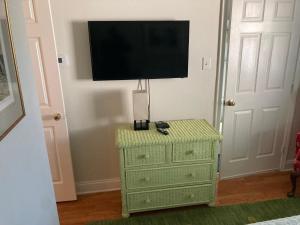 ein Schlafzimmer mit grüner Kommode und einem TV an der Wand in der Unterkunft Green garden view in New Orleans