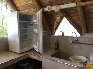a white refrigerator in a kitchen with a window at Alquiler casa completa, Puerto Cayo, hermosa vista in Puerto Cayo