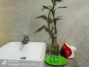 a plant in a bottle next to a bathroom sink at Phonluer Angkor Homestay, in Siem Reap