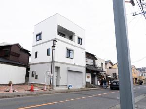 um edifício branco ao lado de uma rua em GLOCE長谷 QRPハウスKAMAKURA em Kamakura