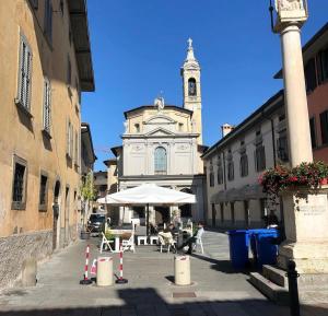 eine Straße mit einem Gebäude mit einem Uhrturm in der Unterkunft Un Piccolo Rifugio nel Borgo in Bergamo