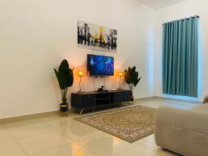 a living room with a couch and a flat screen tv at Alyn Home Kluang IV Netflix Wifi Coway in Kluang