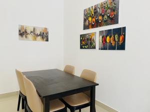 a dining room with a black table and chairs at Alyn Home Kluang IV Netflix Wifi Coway in Kluang
