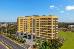 un edificio giallo alto accanto a una strada di HIIVE by Fusion Binh Duong New City a Xóm Ông Phùng