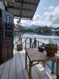 a wooden deck with a table and a view of the water at Jonnie's Riverside Resort in Ko Chang