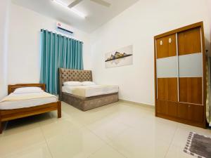 um quarto com duas camas e uma cadeira em Alyn Home Kluang IV Netflix Wifi Coway em Keluang