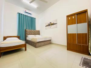 a room with two beds and a chair in it at Alyn Home Kluang IV Netflix Wifi Coway in Kluang