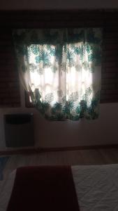 um quarto com uma janela com uma cortina em Departamentos PEUQUE em Comodoro Rivadavia