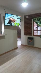 sala de estar con TV de pantalla plana en la pared en Departamentos PEUQUE en Comodoro Rivadavia