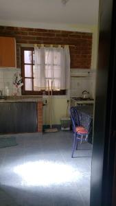 里瓦達維亞海軍準將城的住宿－Departamentos PEUQUE，厨房配有蓝色椅子和窗户