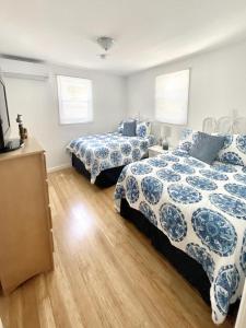 a bedroom with two beds with blue and white sheets at Lbi Vacation Rental Property in Beach Haven
