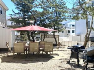 een tafel en stoelen met een parasol en een grill bij Lbi Vacation Rental Property in Beach Haven