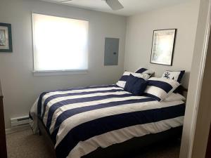 um quarto com uma cama com riscas azuis e brancas em Stunning Apartment In Surf City With 3 Bedrooms, Internet And Wifi em Surf City