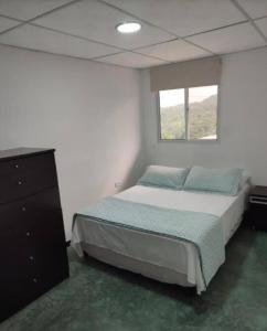 1 dormitorio con 1 cama, vestidor y ventana en Apartamentos - Brisas del Mirador - Panamá Campestre 