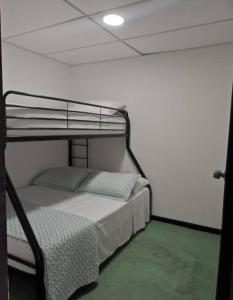 a bedroom with a bunk bed in a white room at Brisas del Mirador - Apartamentos - Panamá Campestre in Cerro Zahino +1 photo