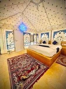 a bedroom with a large bed and a rug at Best Desert Camp In Jaisalmer Red Velvet in Jaisalmer