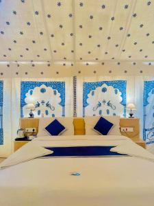 a bedroom with a large bed with blue and white walls at Best Desert Camp In Jaisalmer Red Velvet in Jaisalmer