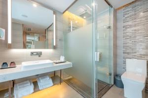 a bathroom with a sink and a glass shower at Lavande Hotel Shenzhen Baoan International Convention and Exhibition Center in Shenzhen