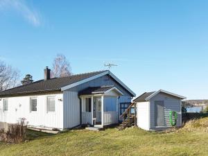 ein kleines weißes Haus auf einem Grashügel in der Unterkunft Holiday home Uddevalla X in Uddevalla