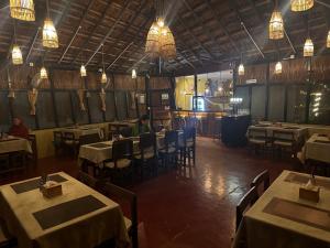 a dining room with tables and chairs and lights at Glampin By Tharu Garden in Sauraha