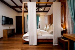 a bedroom with a canopy bed in a room at Little Chembaka in Kumarakom