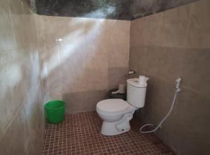 a bathroom with a toilet and a green bucket at Famangkor Homestay in Yennanas Besir