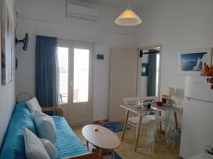a living room with a blue couch and a table at Logaras Seaview Apartment in Logaras +47 photos