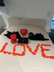 Een bed met het woord liefde erop. bij Beau gîte avec jacuzzi in Barr