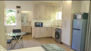 a kitchen with a refrigerator and a table and a microwave at Avonlea Guest House in Kloof