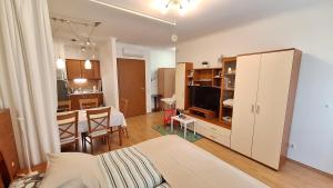 a bedroom with a bed and a kitchen with a table at Sunny Apartman in Siófok