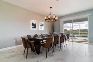 a dining room with a black table and chairs at Lovely Pool Home with Spa and Game Room condo in Davenport