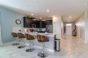 a kitchen with a counter and bar stools at Lovely Pool Home with Spa and Game Room condo in Davenport