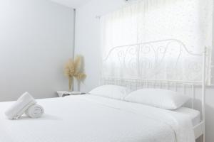 ein weißes Schlafzimmer mit einem weißen Bett und einem Fenster in der Unterkunft Hide & Seek River Villa in Ban Wang Wa (1)
