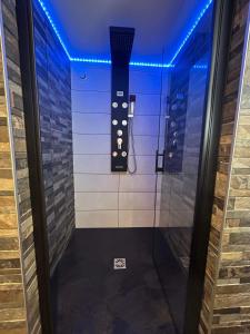 uma cabina de duche ao nível do chão num quarto com luzes azuis em Beau gîte avec jacuzzi em Barr