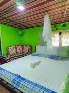 uma cama grande num quarto com uma parede verde em A. Zaragosa Lodging House em San Vicente