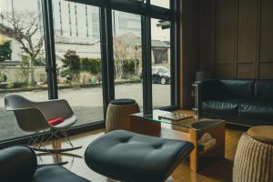 a living room with chairs and a table and windows at TSURUOKA GINZA 朙 sukima in Tsuruoka