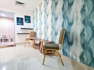 a room with two chairs and a table and a wall at Gardenia Townhouse in Dubai