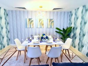 a dining room with a white table and chairs at Gardenia Townhouse in Dubai