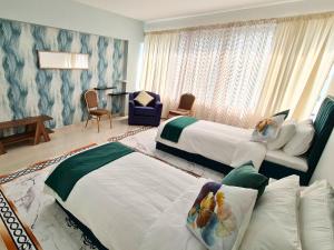 a hotel room with two beds and a table at Gardenia Townhouse in Dubai